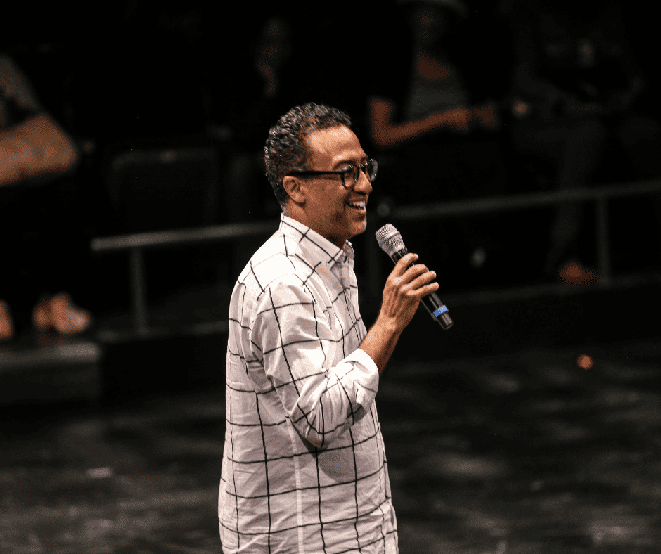 Founder C. Brian Williams holds a microphone and delivers at joyous speech at Step Afrika!'s culminating Summer Steps performance